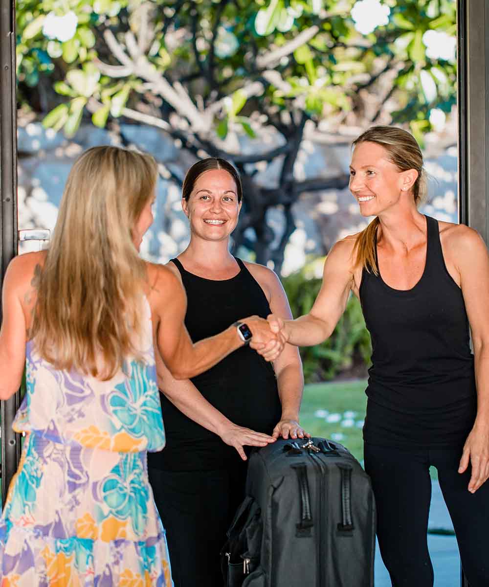 Dani and Tiffany being greeted by the customer at the front door of her home