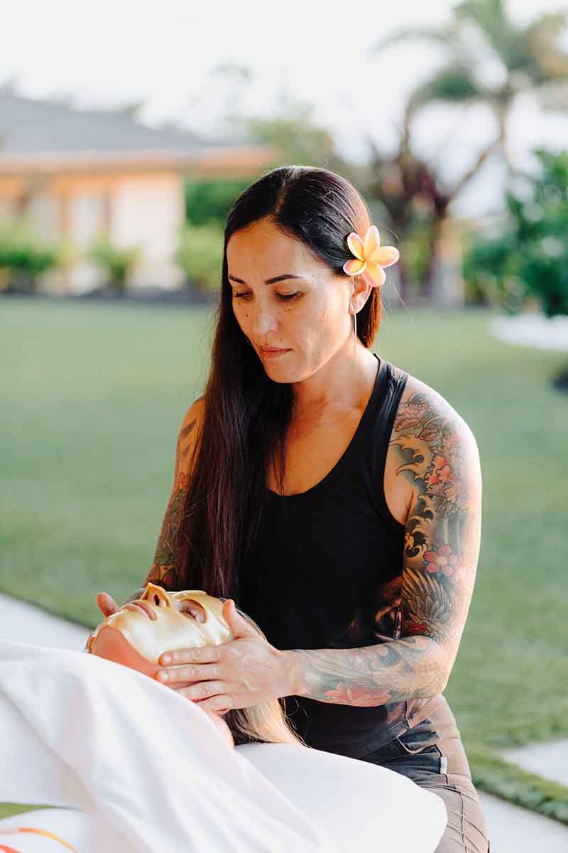 Laura applying a collagen face mask during a mobile massage therapy