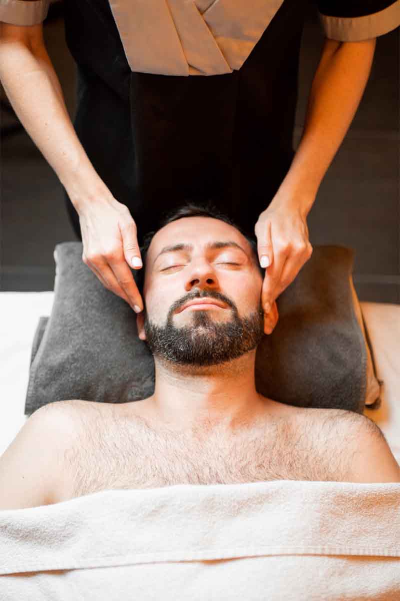 Man receiving a therapeutic facial massage