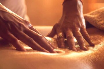 Lomilomi massage therapist working on the client's lower back